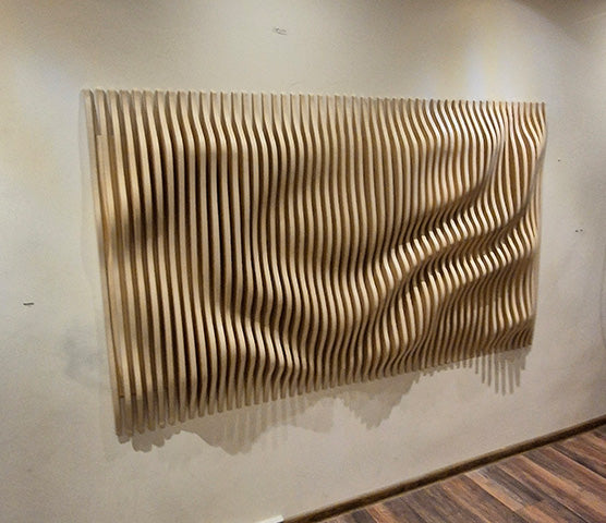 Natural wood parametric wave wall panel mounted in a residential interior, natural birch plywood finish with veneer edge, modified BFW PP1 design