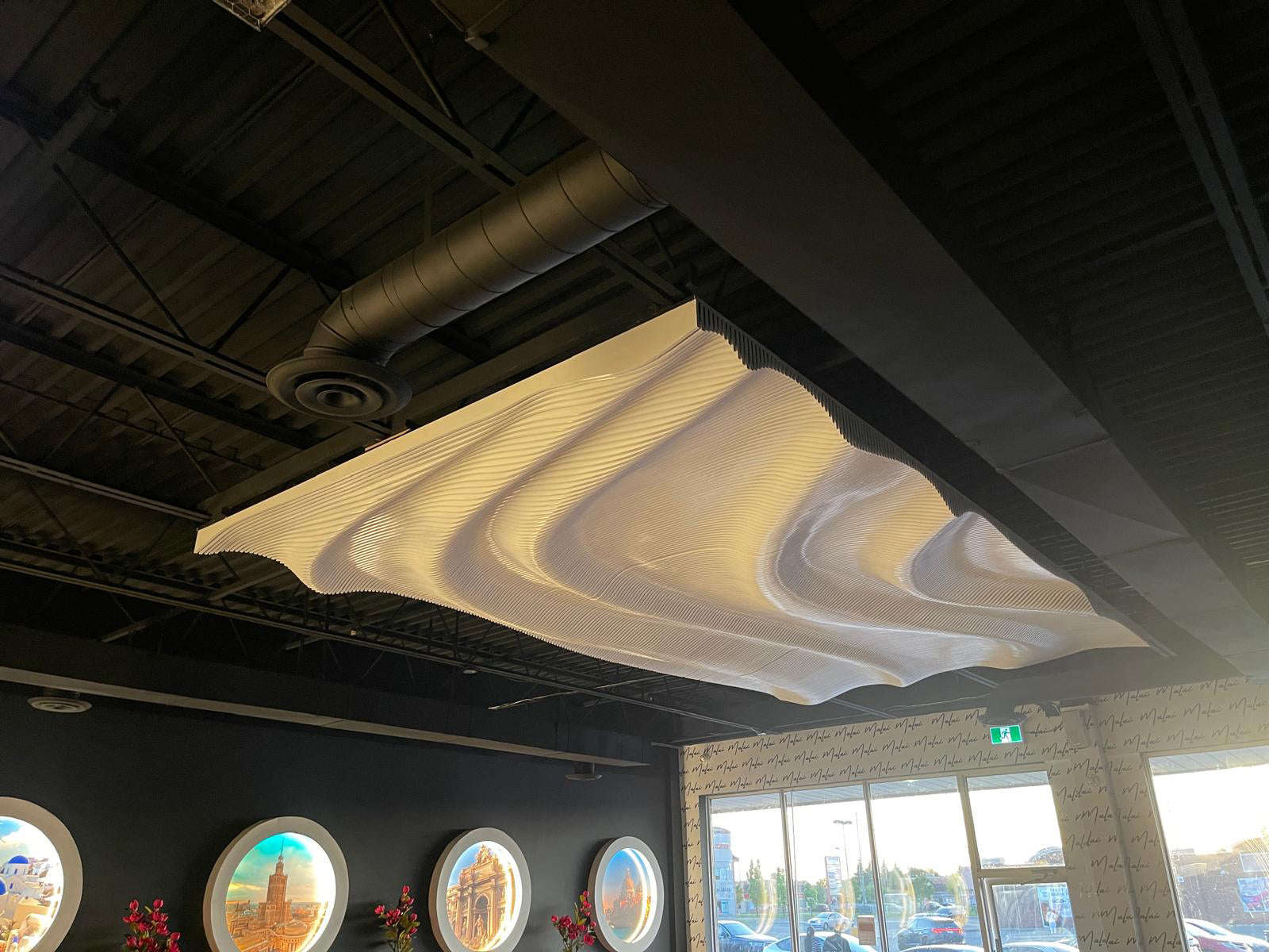 Parametric wave ceiling panel installation in a restaurant, white painted finish, organic wave forms spanning the full ceiling, modified BFW PP6 design