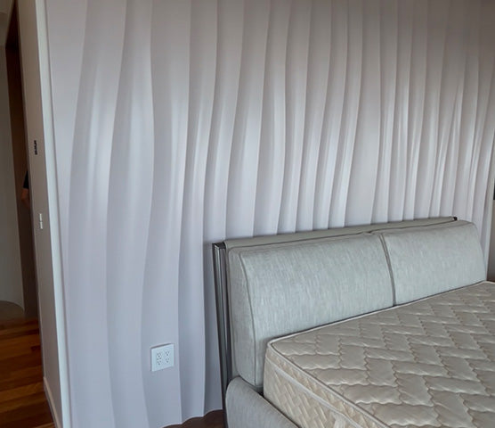 White 3D wave wall panel installed as a feature wall behind a bed in a residential bedroom, based on BFW WP6 design